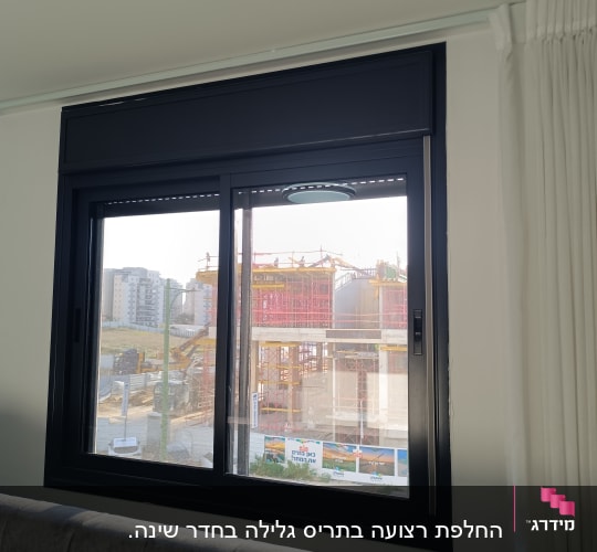 חלון עם תריסים נראים בבניין מגורים